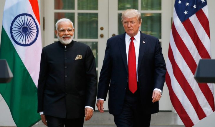 Smiling Narendra Modi And Donald Trump Standing In The Background Of Indian & USA Flags.