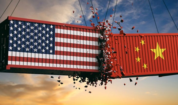 USA And Chinese Flags Crashed Containers On Sky At Sunset Background Representing The Trade War.